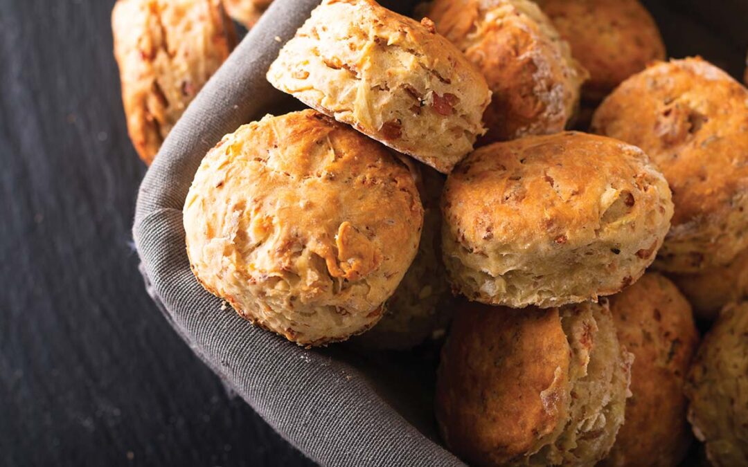 Food concept Fresh baked Homemade buttery, salty Ham and cheese scones on black background