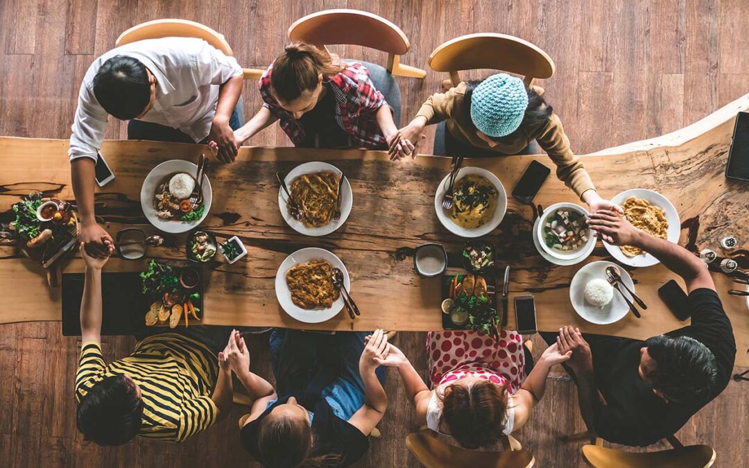 Group of friend pray before having nice food and drinks, enjoyin